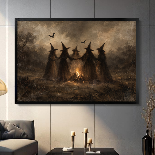Black framed witches around a bonfire canvas artwork displayed on a gray wall in a neutral room.