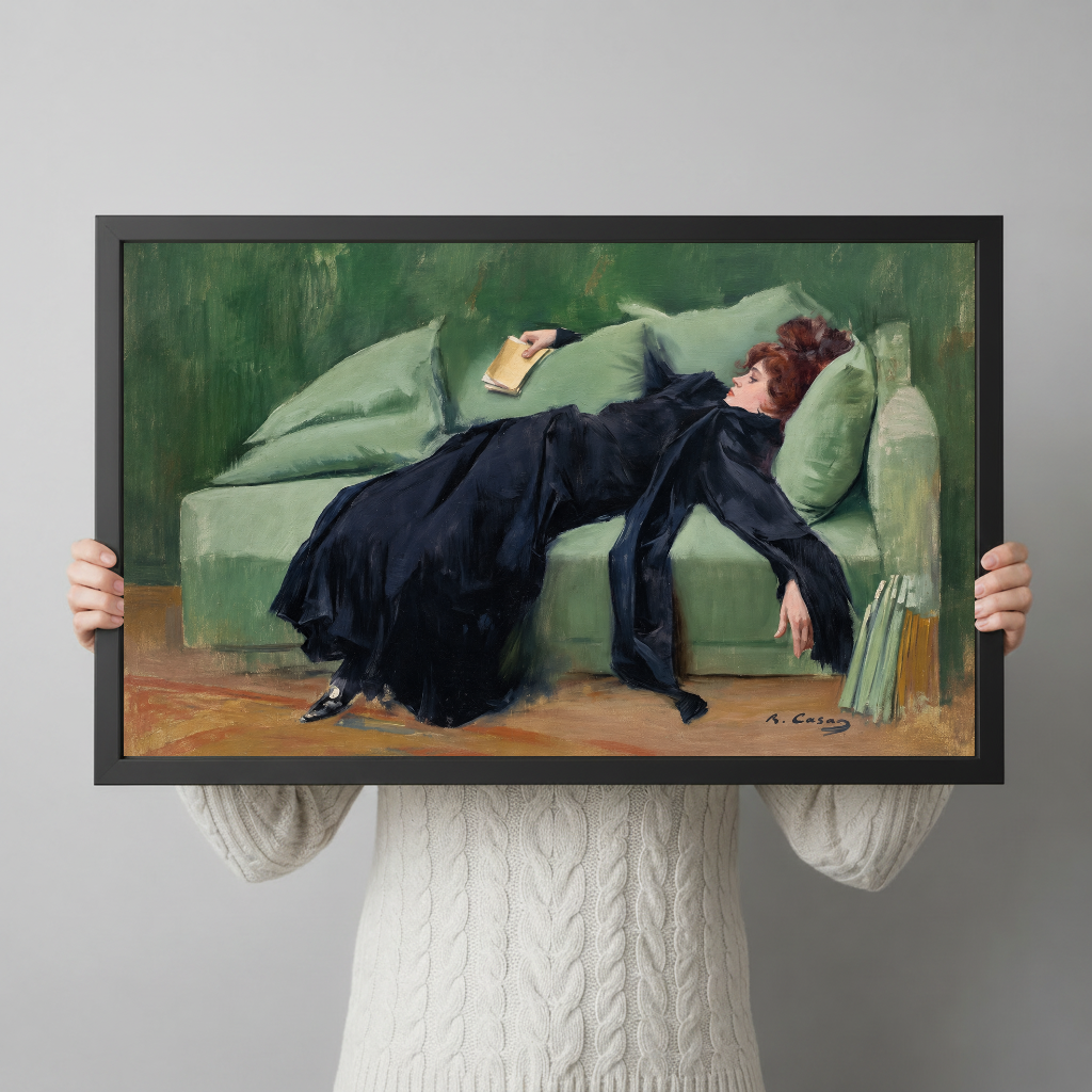 A person holds framed reading woman artwork to demonstrate its landscape proportions and scale.