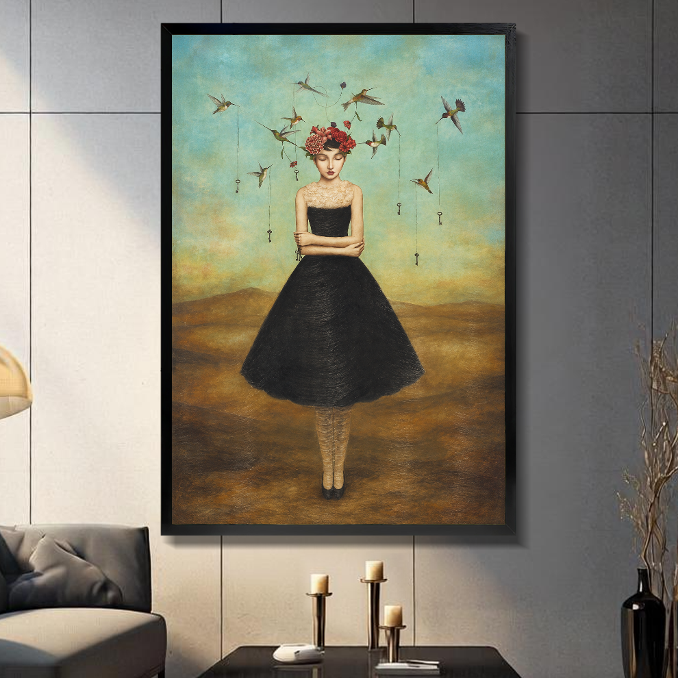 Black framed canvas depicting a flower crowned woman with hummingbirds on a gray paneled wall with candles.