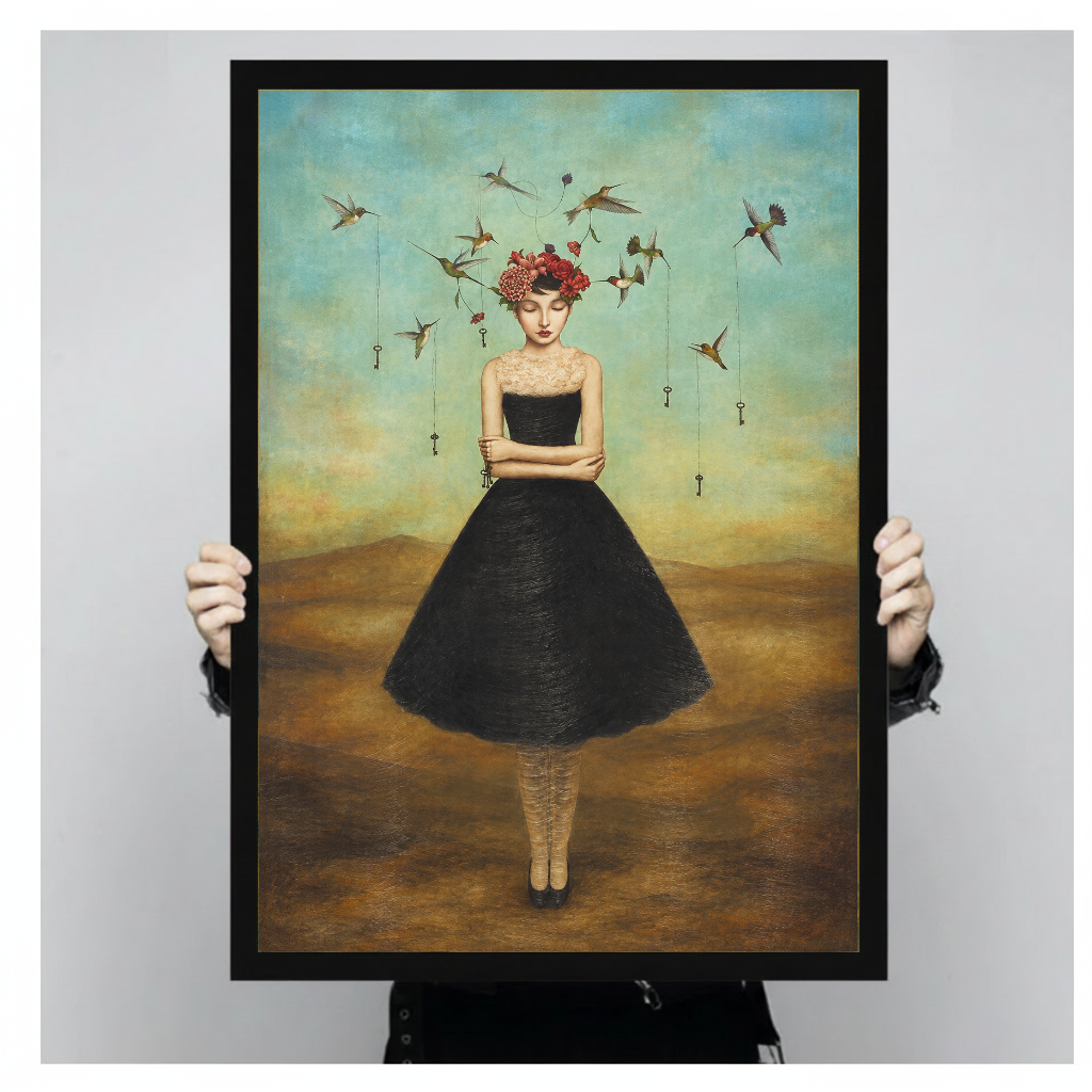 Framed artwork of a flower crowned woman with hummingbirds held by a person against a pale backdrop.