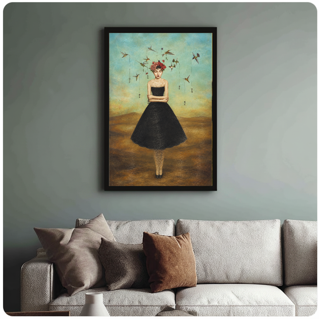Framed artwork of a flower crowned woman with hummingbirds above a sofa with muted cushions.