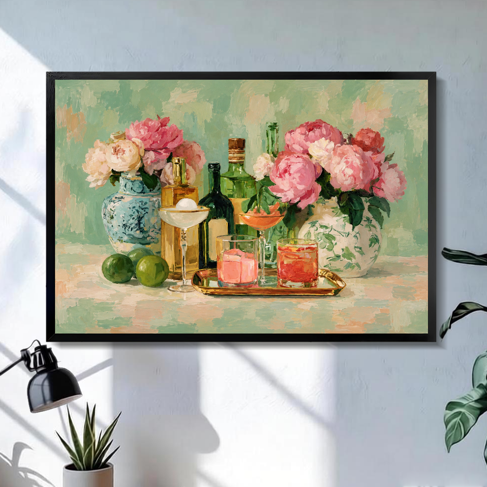 Black framed floral cocktail still life canvas above a bright desk with lamp and green plant.