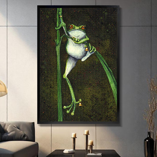 Black framed canvas depicting a frog holding bells among reeds on a gray paneled wall with candles.
