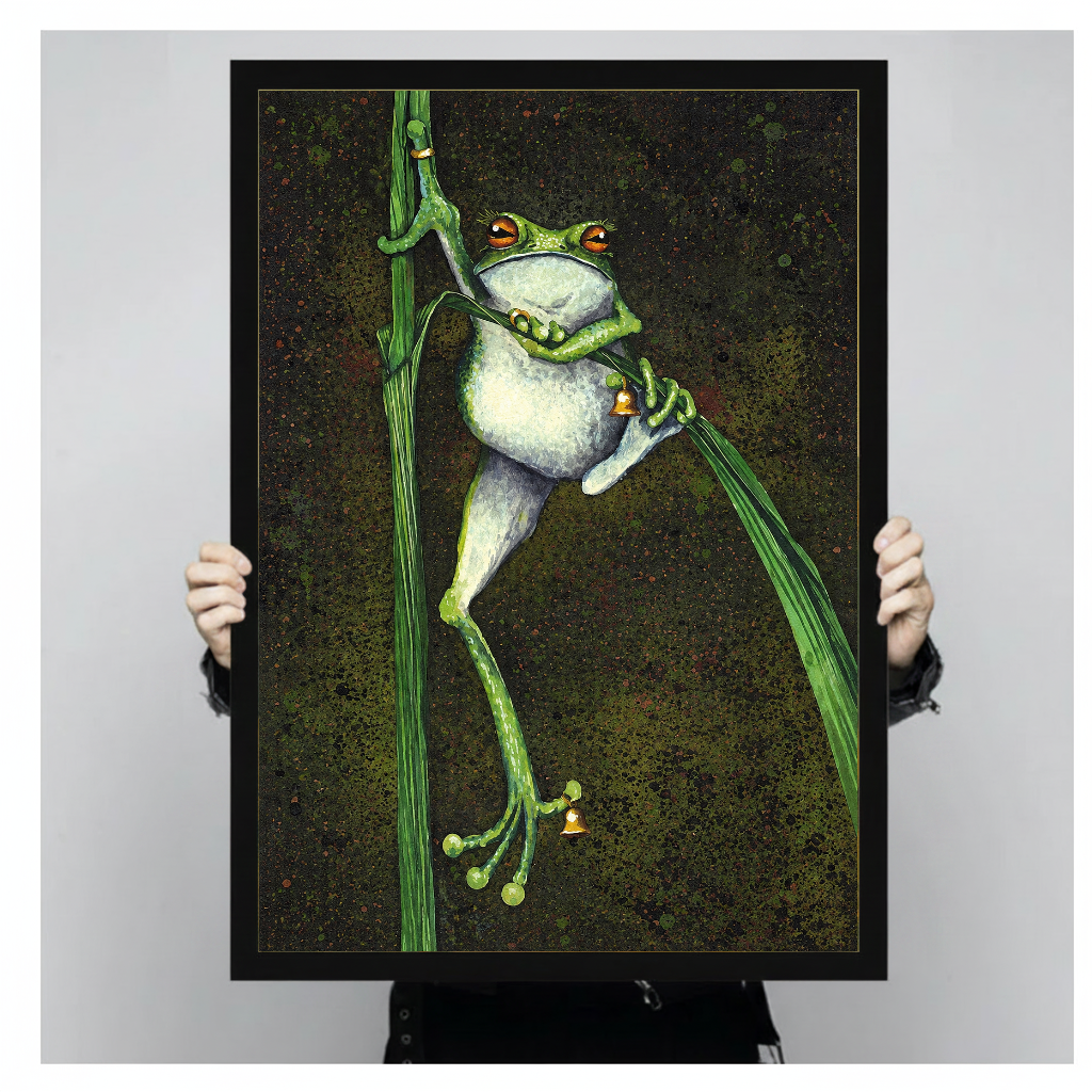 Framed artwork of a frog holding bells among reeds held by a person against a pale backdrop.