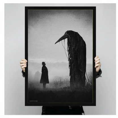 Person holding black framed gothic raven encounter artwork against a plain pale background.
