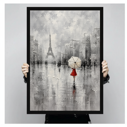 Framed artwork of a red dressed woman beneath an umbrella held by a person against a pale backdrop.