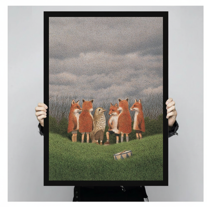 Person holding a black framed portrait canvas depicting woodland foxes with bird and drum.
