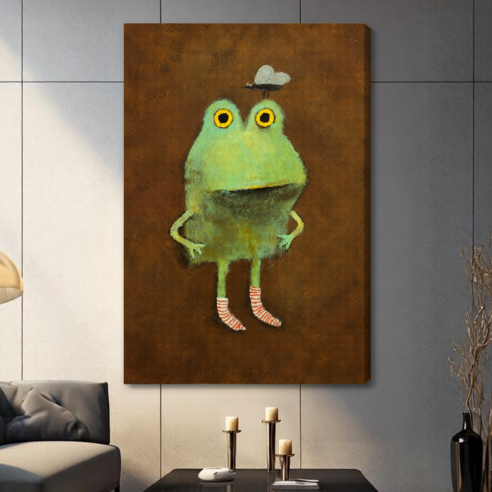 Stretched canvas depicting a green frog wearing striped socks displayed on a gray paneled wall with candles.