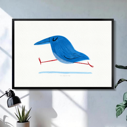 Black framed running blue bird canvas above a bright desk with lamp and green plant.
