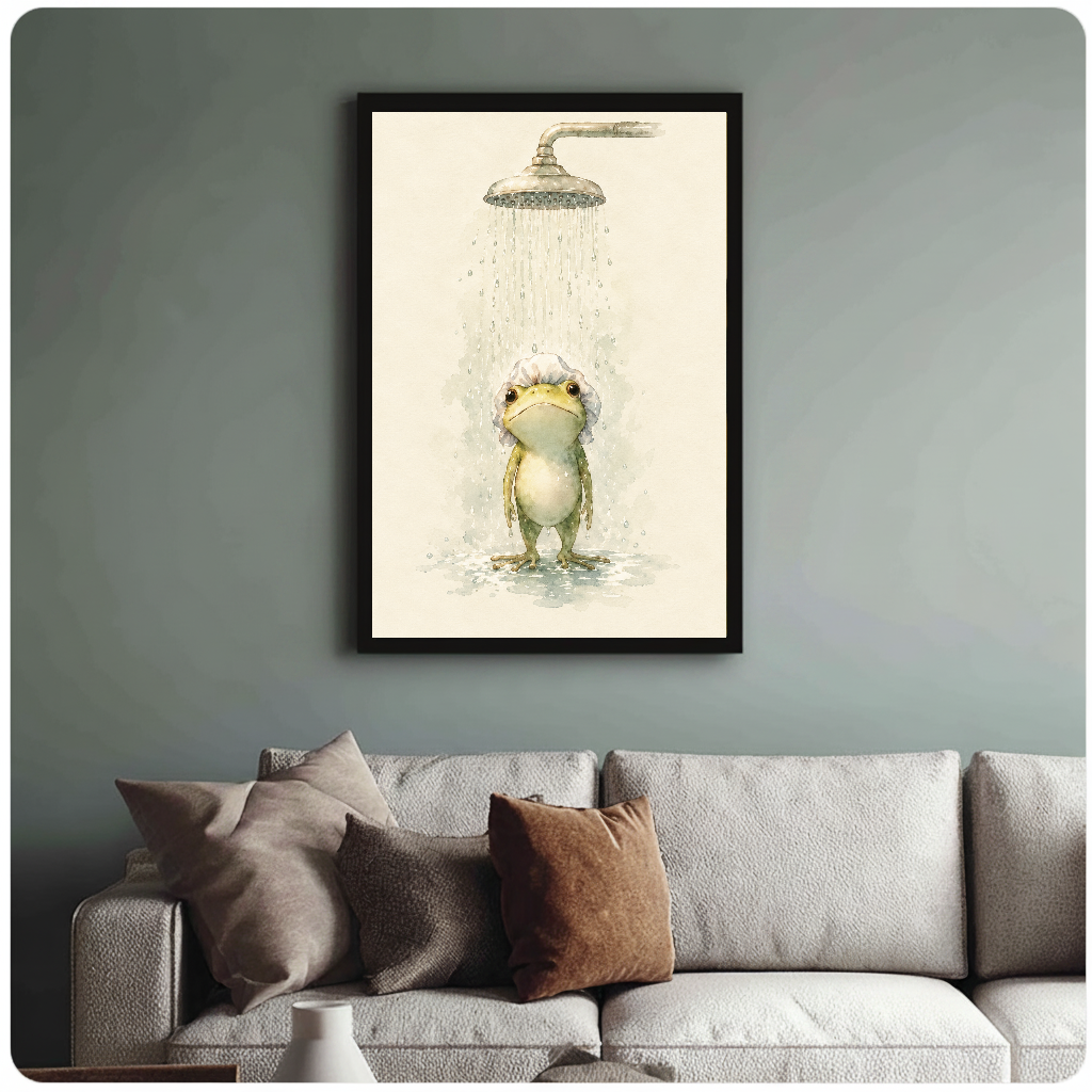 Framed watercolor shower frog painting above a sofa with muted cushions against a green-gray wall.