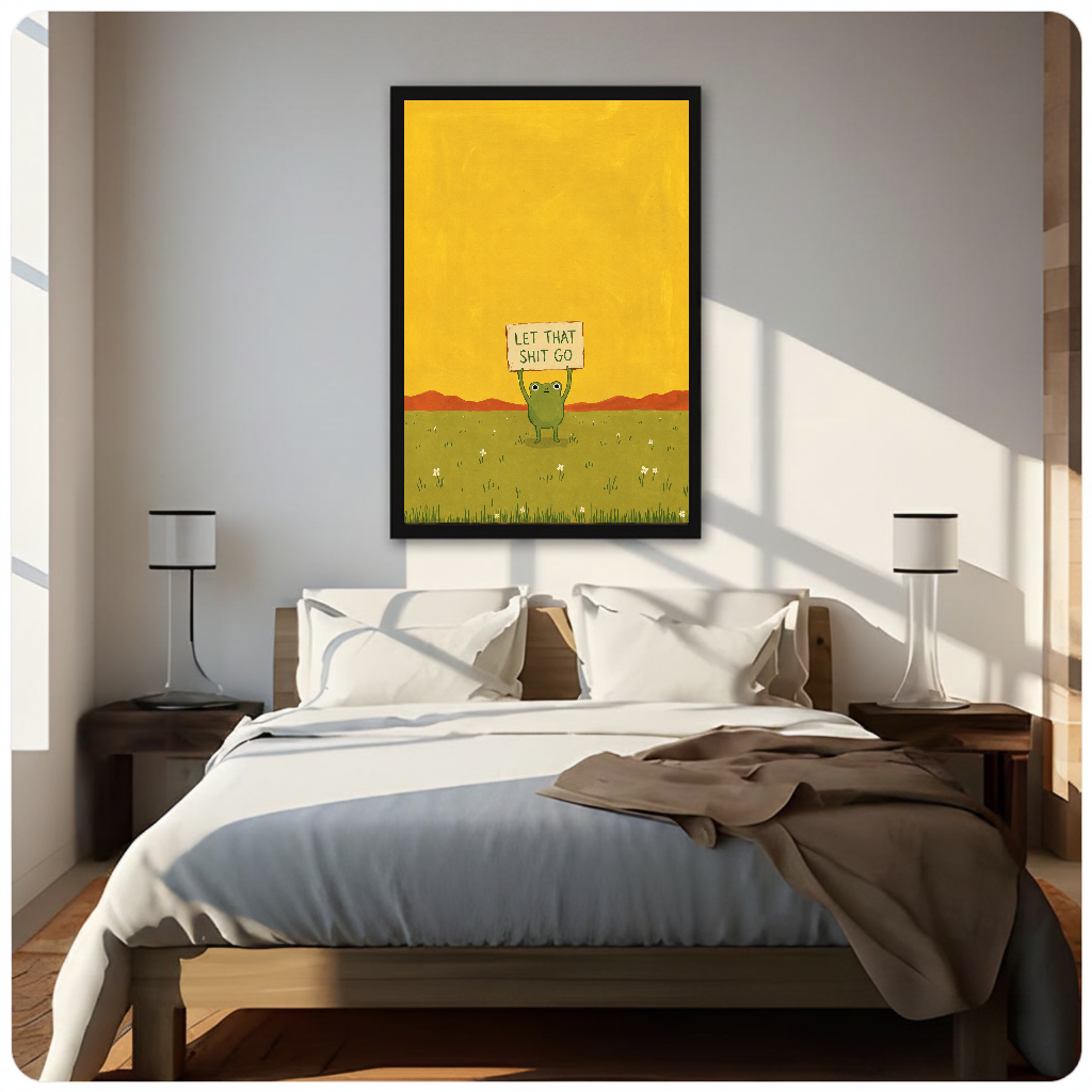 Framed artwork of a green frog holding a humorous sign above a neutral bed between two bedside lamps.
