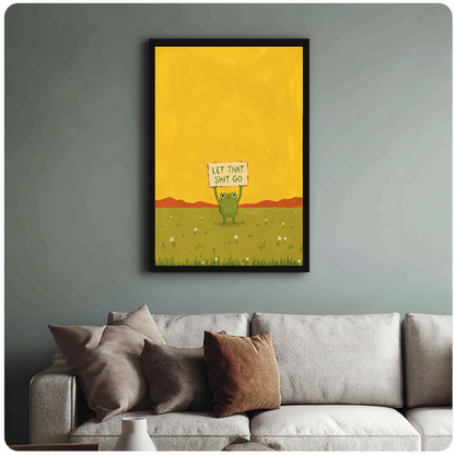 Framed artwork of a green frog holding a humorous sign above a sofa with muted cushions.