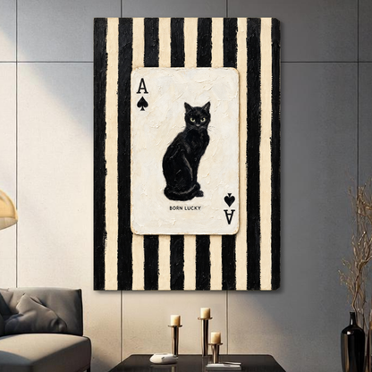 Stretched canvas depicting a black cat inside an ace playing card displayed on a gray paneled wall with candles.