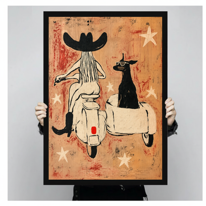 Person holding black framed cowgirl scooter dog artwork against a plain pale background.
