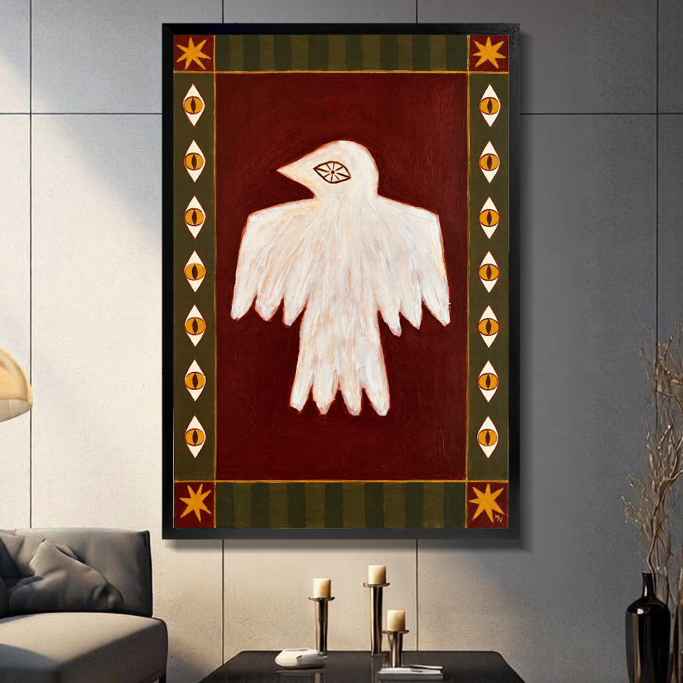 Black framed folk bird with eyes canvas above a console beside a sofa in a paneled room.