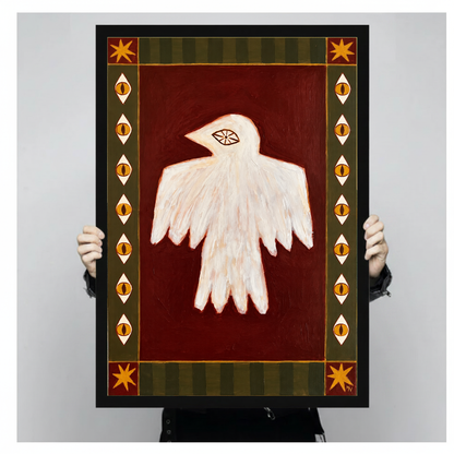 Person holding black framed folk bird with eyes artwork against a plain pale background.