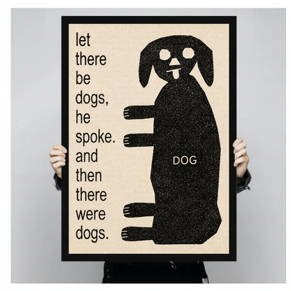 Framed artwork of a dog beside whimsical creation text held by a person against a pale backdrop.