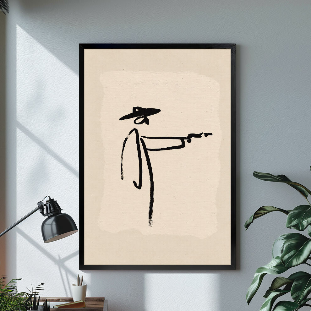 Black framed minimalist brushstroke cowboy canvas above a desk with lamp and green plant.