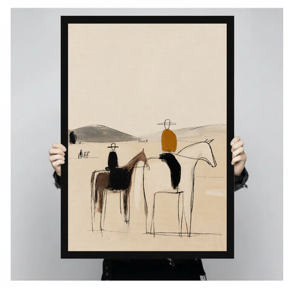 Person holding black framed abstract horseback riders artwork against a plain pale background.
