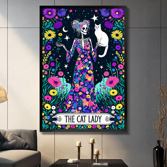 Black framed floral skeleton cat lady canvas on a dark paneled wall beside warm candles.