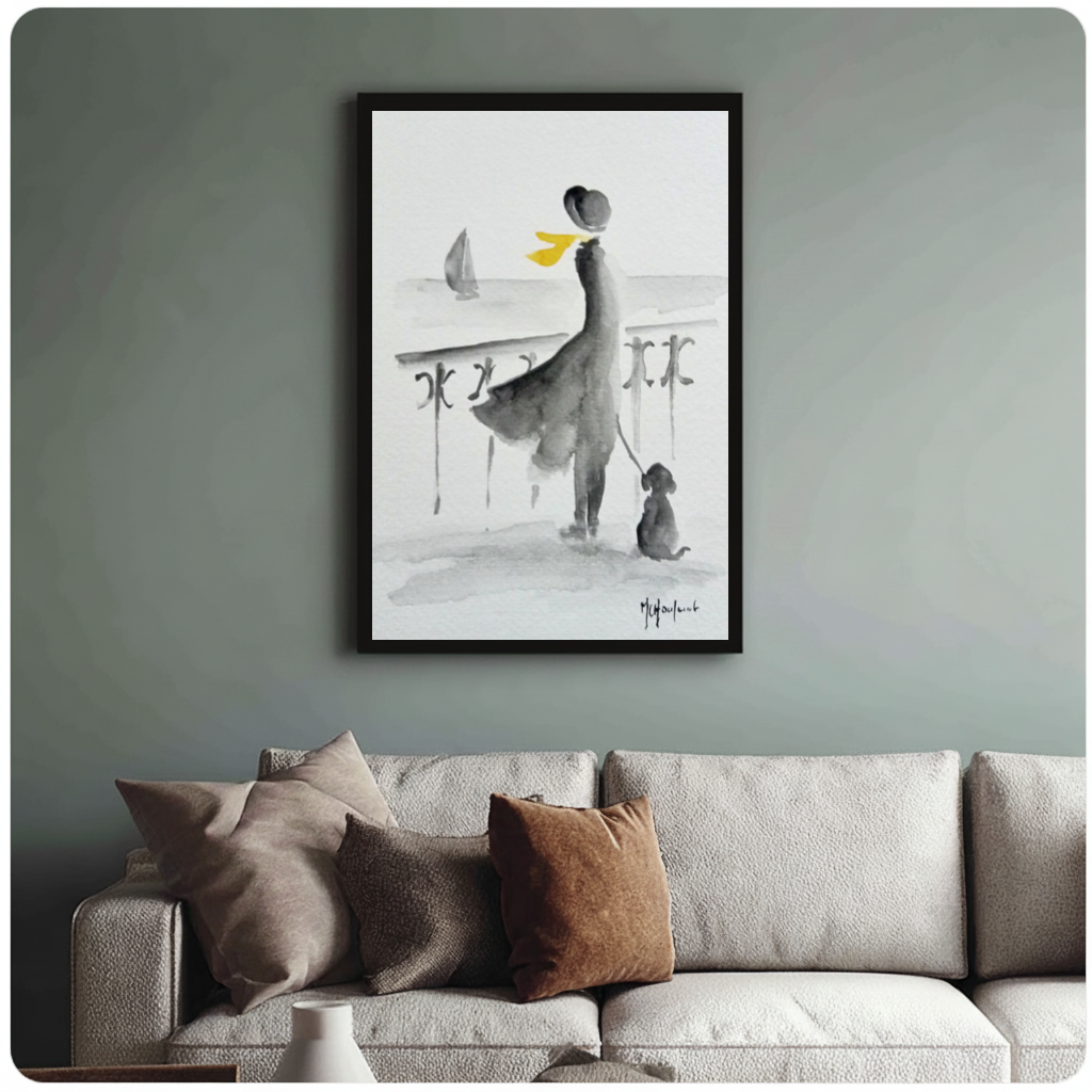 Framed yellow scarf seaside companions canvas above a neutral sofa with cushions against a muted wall.