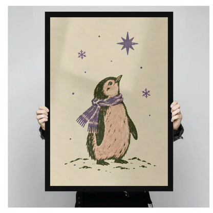 A person holds black framed penguin under purple stars canvas against a light neutral background.
