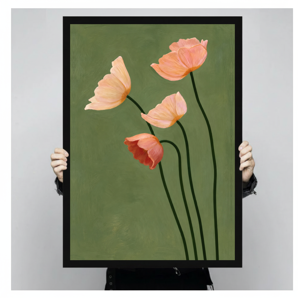 A person holds black framed four blush poppies canvas against a light neutral background.