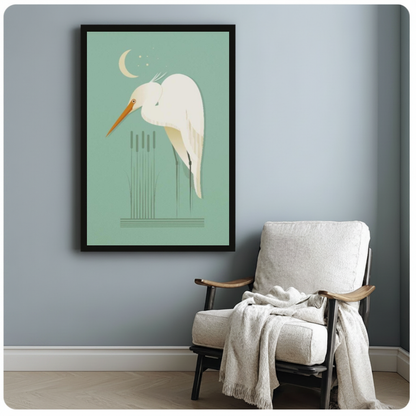 Framed moonlit white egret canvas beside a pale reading chair on a blue gray wall.