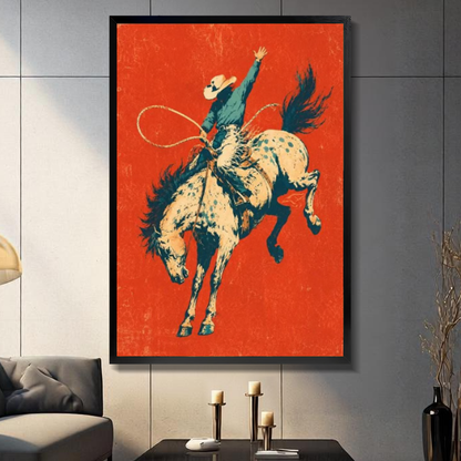 Black framed bucking bronco rodeo rider canvas on a dark paneled wall beside warm candles.