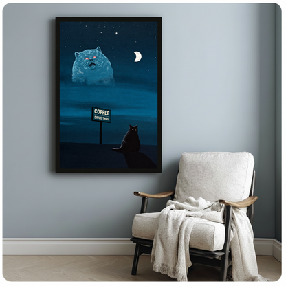 Framed night cat and giant vision canvas beside a pale reading chair on a blue gray wall.