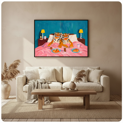 Framed tigers enjoy pizza in bed canvas above a neutral sofa beside pampas grass and a coffee table.