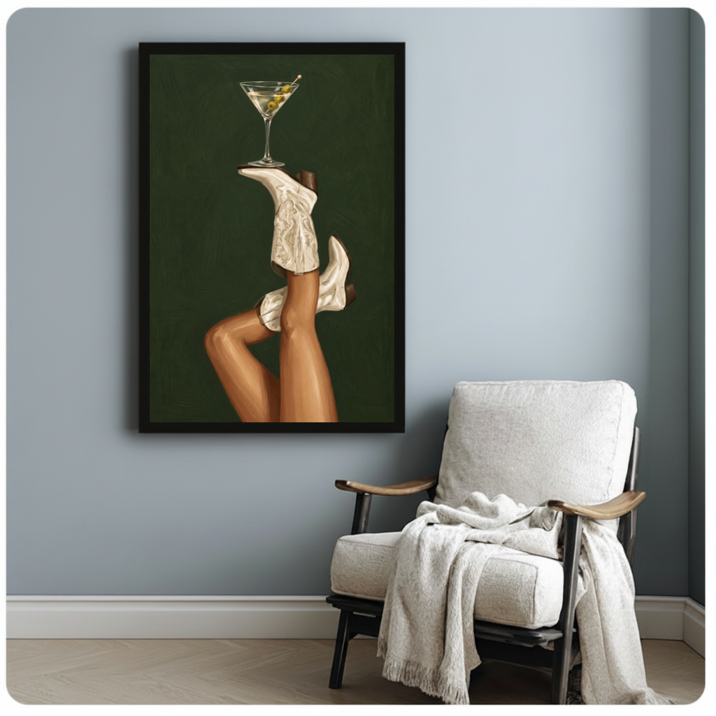 Framed cowgirl boots martini balance canvas beside a pale reading chair on a blue gray wall.