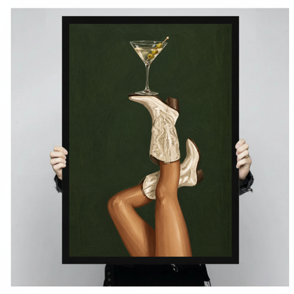 Framed cowgirl boots martini balance canvas held by a person against a light neutral background.