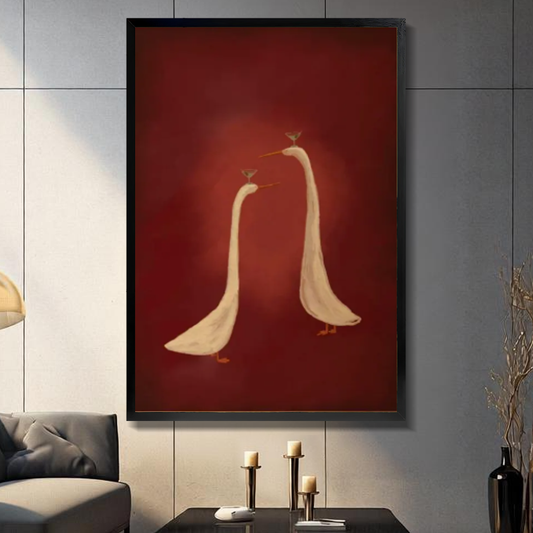 Black framed elegant goose balancing pair canvas on a dark paneled wall beside warm candles.