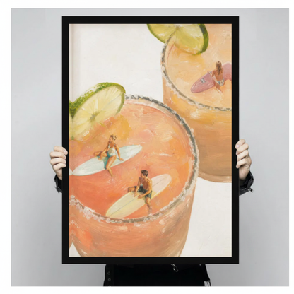 Framed tiny surfers cocktail pools canvas held by a person against a light neutral background.