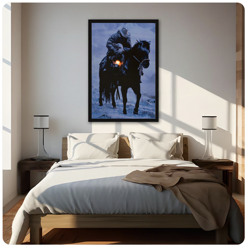 Framed cowboy carrying lamb canvas above a neutral bed beside soft bedroom lighting and lamps.