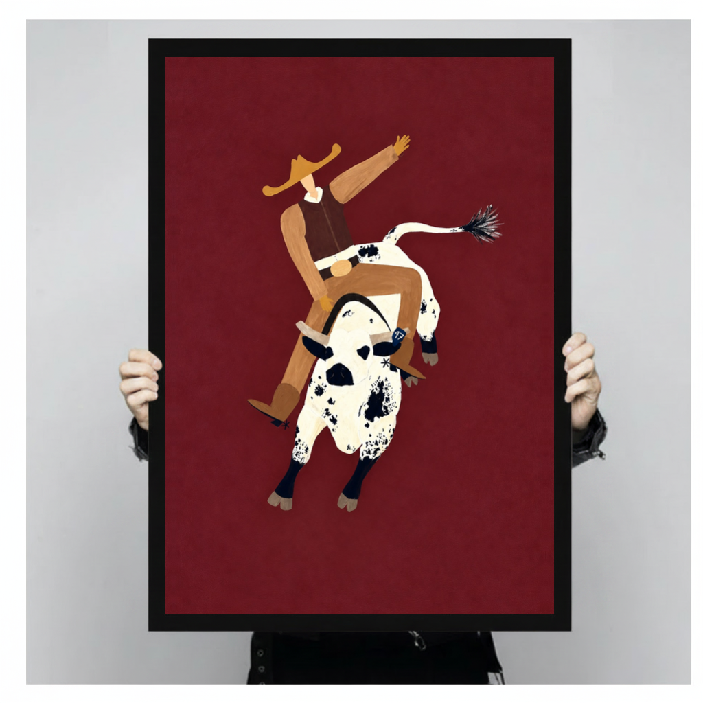 Framed burgundy rodeo rider canvas held by a person against a light neutral background.