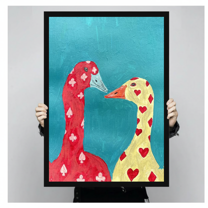 Framed playing card geese canvas held by a person against a light neutral background.