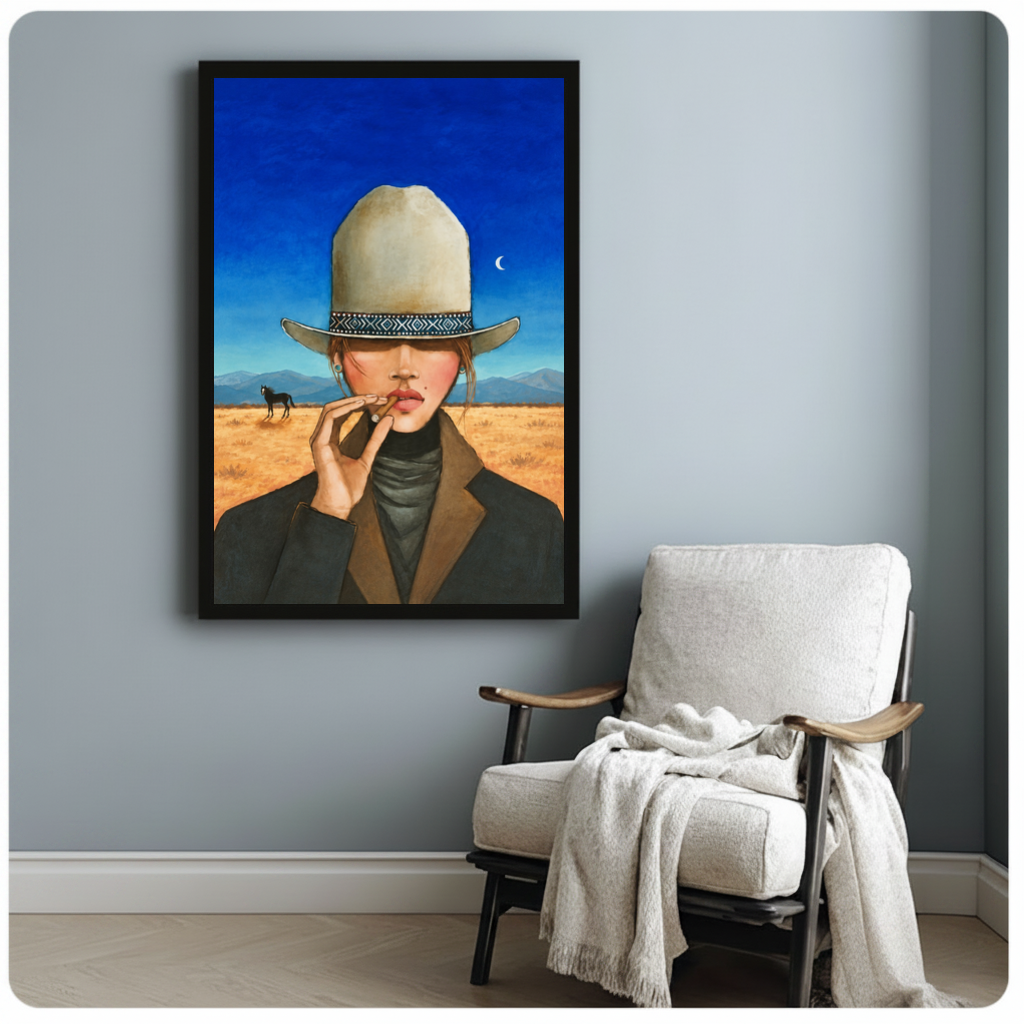 Framed blue sky cigar cowgirl canvas beside a pale reading chair on a blue gray wall.