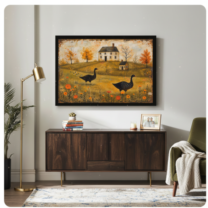 Framed autumn geese farmhouse canvas above a wooden sideboard beside books and an angled brass lamp.