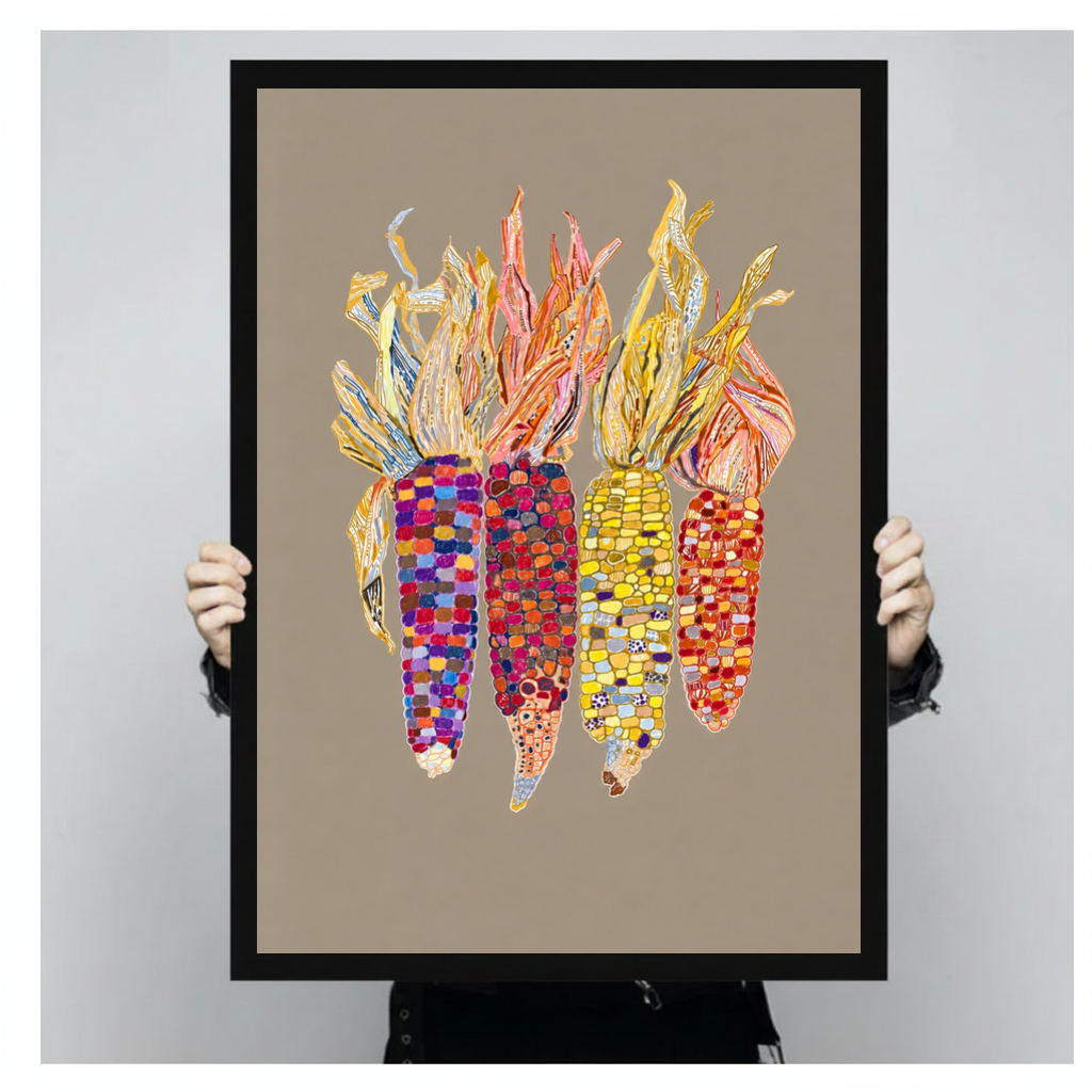 Framed colorful beaded corn canvas held by a person against a light neutral background.
