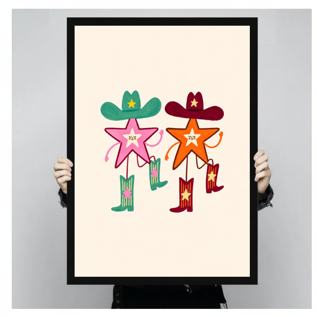 Framed two cowboy stars canvas held by a person against a light neutral background.