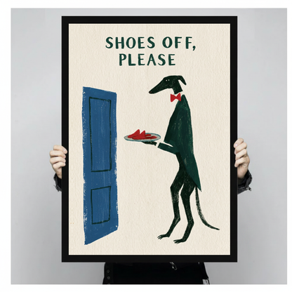 Framed shoes off doorman dog canvas held by a person against a light neutral background.
