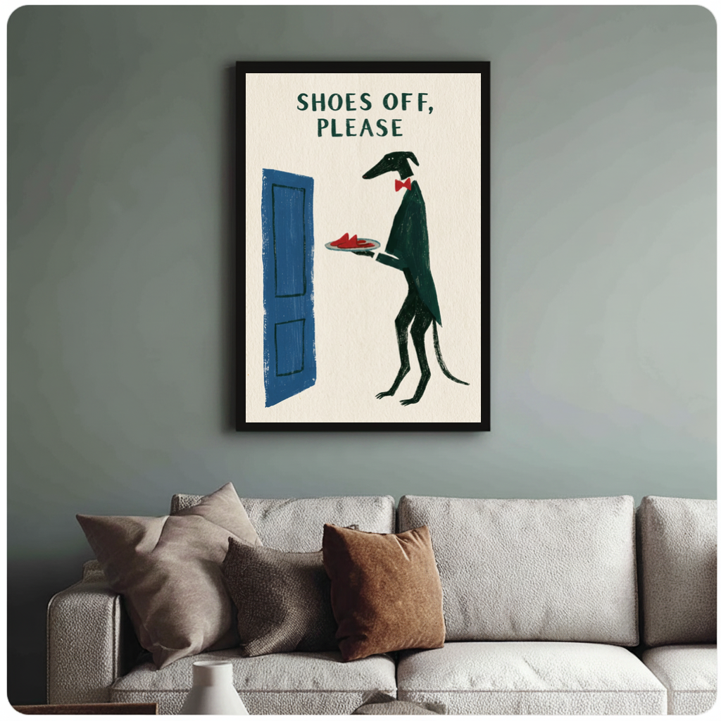 Framed shoes off doorman dog canvas above a neutral sofa with cushions against a muted wall.