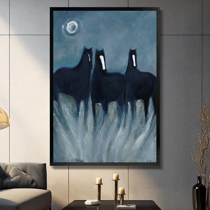 Black framed three ghostly black horses canvas on a dark paneled wall beside warm candles.