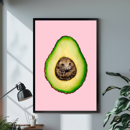 Black framed avocado hedgehog canvas on a pale wall above a desk and plant.