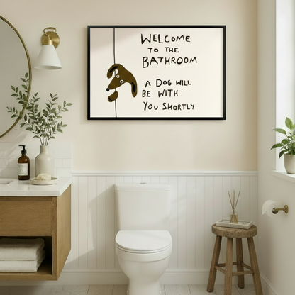 Welcome to the bathroom a dog will be with you shortly humorous line art in black frame above toilet in warm beige bathroom with wainscoting – gold mirror brass sconce wood vanity brown cartoon dog cream background funny dog toilet wall art