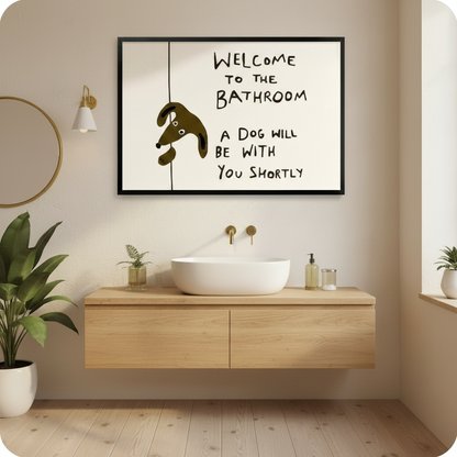 Welcome to the bathroom a dog will be with you shortly humorous line art in black frame above floating wood vanity in warm beige bathroom – gold round mirror wall sconce green plants brown cartoon dog cream background funny bathroom wall art
