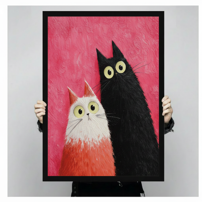 Person holding large framed modern whimsical impasto oil painting fluffy white and orange gradient cat beside tall black cat both with wide round yellow-green eyes and surprised expressions leaning together on vibrant hot pink textured brushstroke background canvas print with both hands against light grey background - close up size reference of funny black white cat duo pink wall art with black frame finish