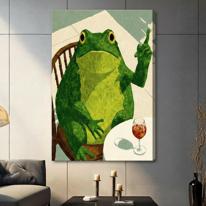 Stretched canvas wall art of a humorous round green frog seated on a vintage wooden chair lifting one finger with a chilled glass of red aperitif on a white table, set against a soft sage and off-white oil-painted background, hung on a dark gray tile wall beside a modern gray sofa with candlestick decor